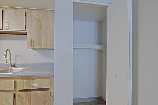 A kitchen with wooden cabinets and a white sink at Connect on Northern, Glendale, AZ 85301