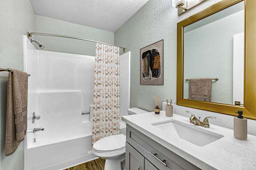 A bathroom with a white toilet, sink, and shower at Tela Verde Apartment Homes, Glendale, 85306