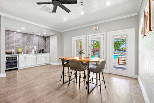 A kitchen with a dining table and chairs in the middle of the room.
