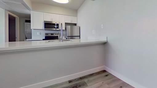 A kitchen with white cabinets and appliances.