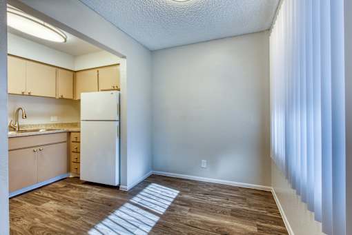 A kitchen with a white refrigerator and wooden cabinets. at The Link Apartments, Mesa, Arizona