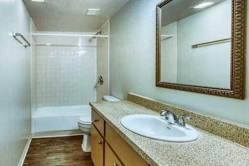 A bathroom with a sink, mirror, and bathtub. at The Link Apartments, Mesa, AZ, 85201