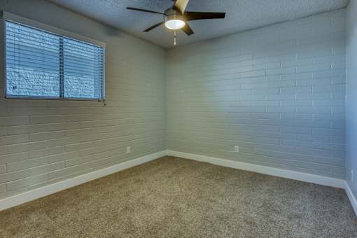 A room with a ceiling fan and a window with blinds. at The Link Apartments, Mesa, Arizona