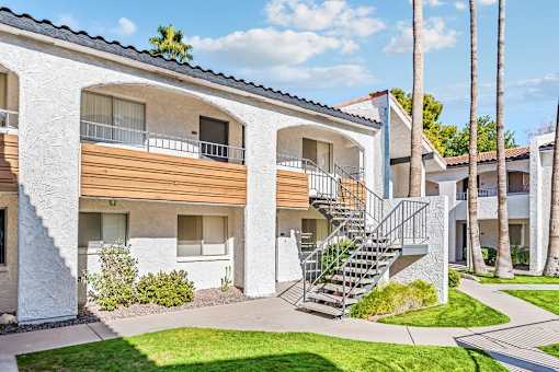 A white building with a balcony and a staircase at Tides on East Cactus Apartments, Arizona