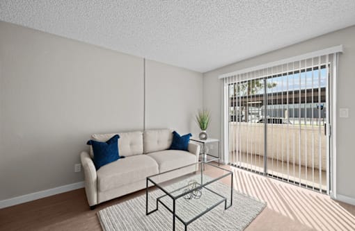 A living room with a white couch and a glass coffee table  at Tides on McDowell, Phoenix