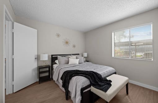 A bedroom with a bed, nightstand, and window  at Tides on McDowell, Phoenix, 85035