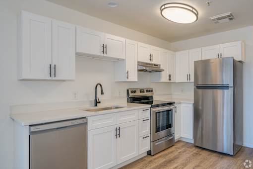 a kitchen with white cabinets and stainless steel appliances