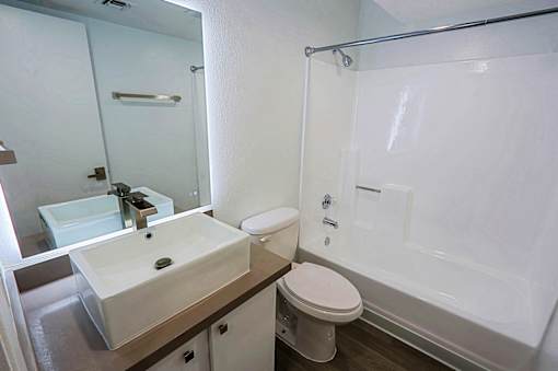 A white toilet sits next to a sink in a bathroom.