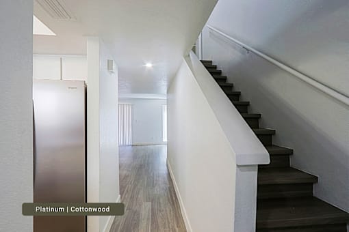A staircase with a white railing and black steps.