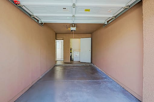 A long hallway with a white door at the end.
