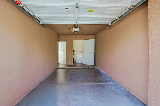 A long hallway with a white door at the end.