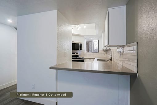 A bathroom with a white vanity and a mirror above it.