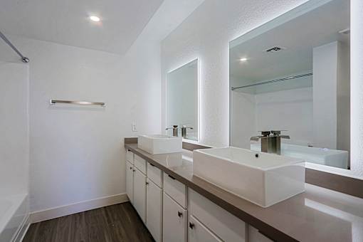 A bathroom with two sinks and a large mirror.