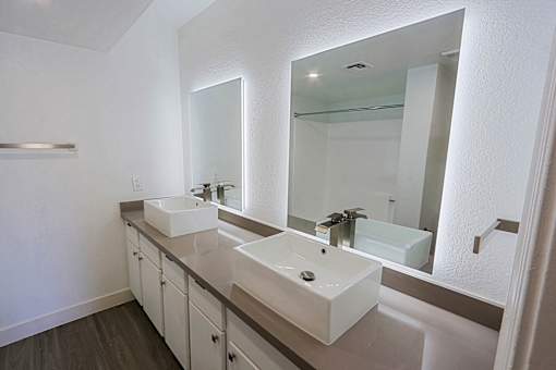 A bathroom with two sinks and a large mirror.