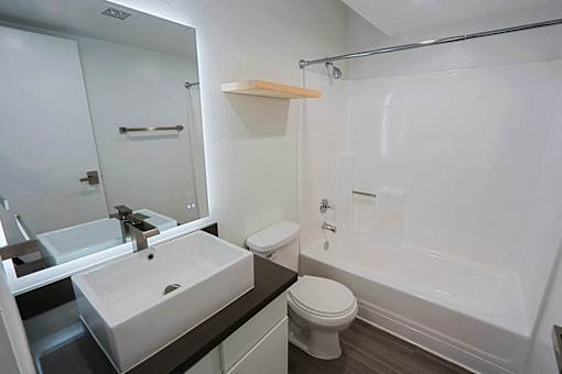 A white toilet sits next to a white sink in a bathroom.
