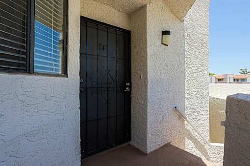 A black door with the number 14 on it is on a white wall.