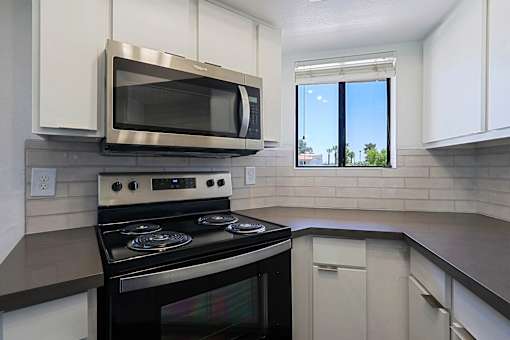 A modern kitchen with a stove and microwave.