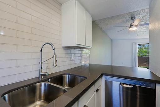A kitchen with a stainless steel sink and dishwasher.