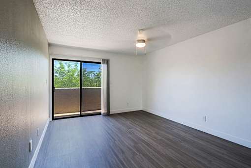 A room with a sliding glass door leading to a backyard.
