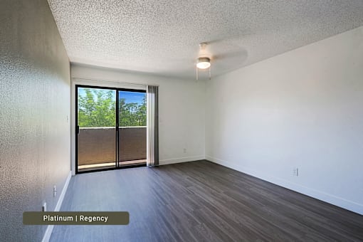 A room with a sliding glass door leading to a backyard.