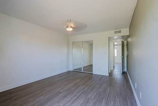 A room with a wooden floor and a white wall.