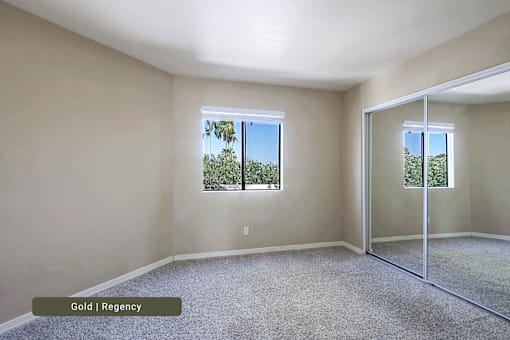 A room with a carpet floor, a window, and a sliding glass door.