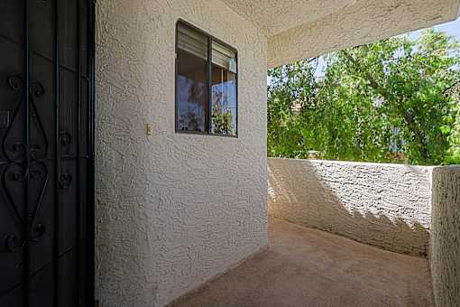 A white wall with a window and a door with a metal handle.