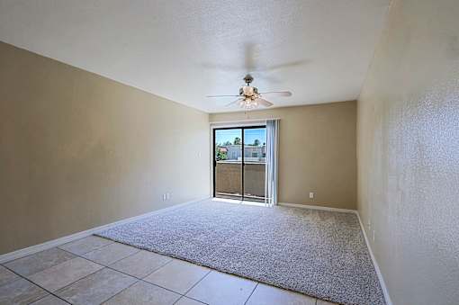 A room with a ceiling fan and a sliding glass door leading outside.