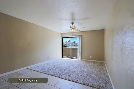 A room with a carpet floor and a ceiling fan.
