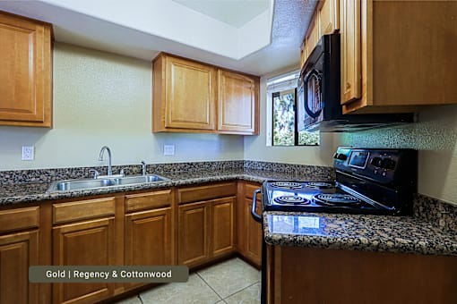 A kitchen with wooden cabinets and a granite countertop.