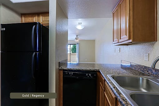 A black fridge in a kitchen with wooden cabinets.