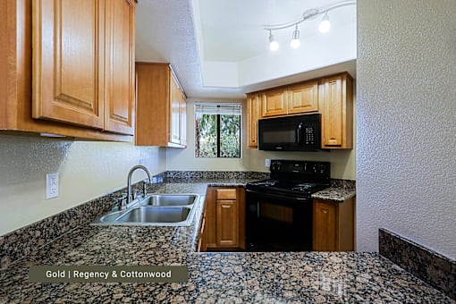 A kitchen with wooden cabinets and a granite countertop.
