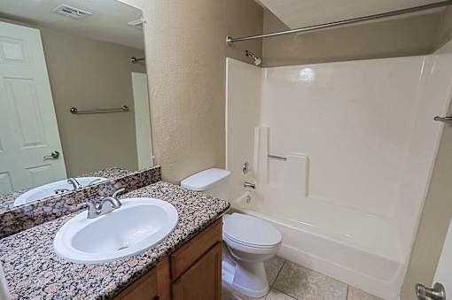 A bathroom with a sink, toilet, and bathtub.