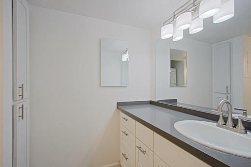 A bathroom with a sink and mirror.