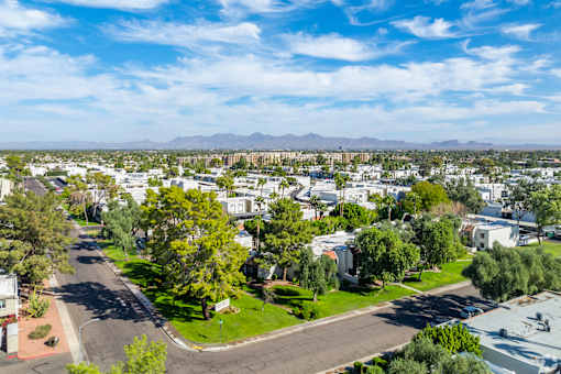 A residential area with houses and trees under a blue sky.