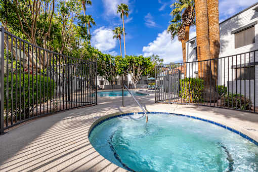 A small pool surrounded by a black fence.