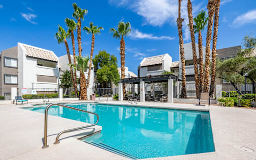 a swimming pool with palm trees in front of a building