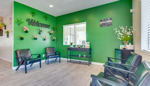 a dentist office with green walls and chairs and a welcome sign