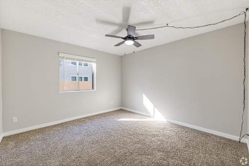 Spacious room with a ceiling fan and a window