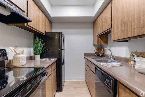 a kitchen with wooden cabinets and stainless steel appliances and a sink
