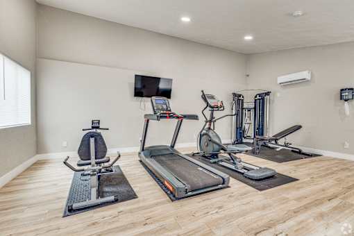 A spacious home gym with a variety of exercise equipment.