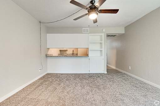 A room with a ceiling fan and a built-in bench.
