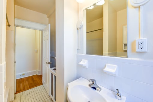 bathroom with vanity, closet and tile flooring at the cortland apartments in washington dc