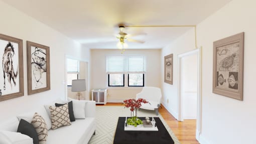 living area with sofa, seating area, coffee table, modern artwork and ceiling fan at the klingle apartments in washignton dc