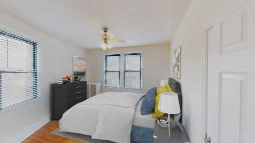 bedroom with bed, nighstands, dresser, large windows and ceiling fan at the klingle apartments in washignton dc