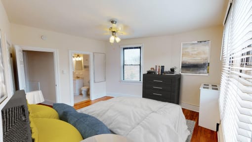 bedroom with bed, dresser, closet and view of bathroom at the klingle apartments in washignton dc