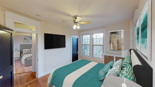 bedroom with bed, dresser, large windows, ceiling fan and tv at the cortland apartments in washington dc