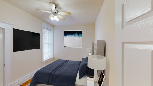 bedroom with bed, tv, nightstand and large window at dupont apartments in washington dc