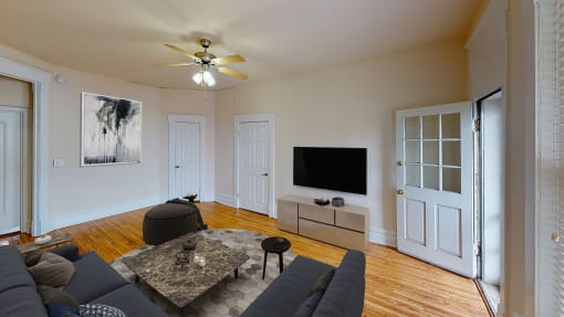 living area with sofa, coffee table, credenza, tv, and hardwood floors at dupont apartments in washington dc