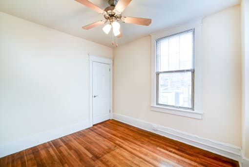 vacant bedroom with hardwood flooring and ceiling fan at the cortland apartments in washington dc